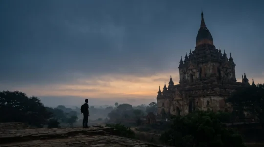 Viaggiatore solitario ammira un monumento iconico all'alba in atmosfera intima e autentica